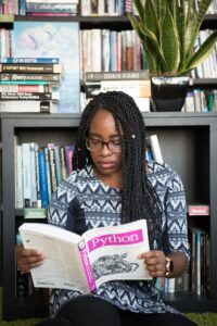 Home African American woman studying Python programming in a library setting.