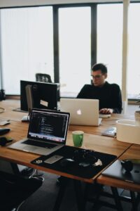 Home A web developer working on code in a modern office setting with multiple devices.