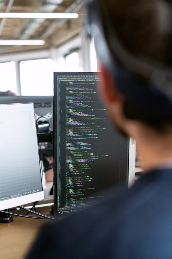 pexels photo 3861959 A male software engineer working on code in a modern office setting.
